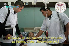 dos participantes del curso de acupuntura visitan a una paciente durante las practicas de acupuntura en el  hospital